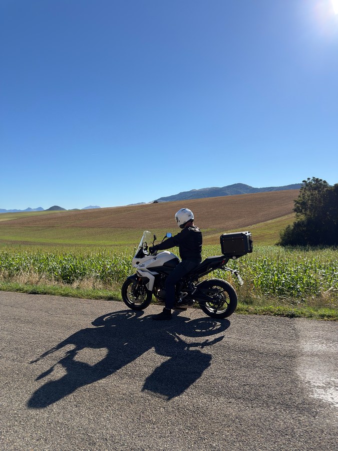 Moto et pilote sur une route de campagne du plateau matheysin