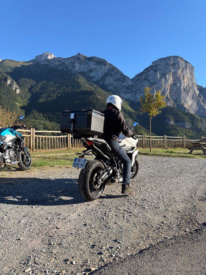 Pilote sur sa moto au belvédère, face aux montagnes du Dévoluy