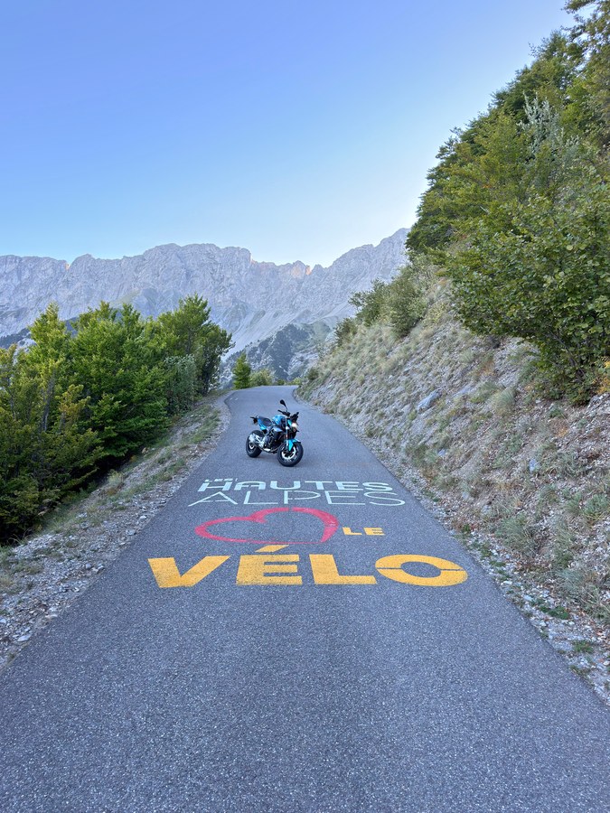Moto sur la chaussée peinte HAUTES-ALPES LE VÉLO au col du Noyer
