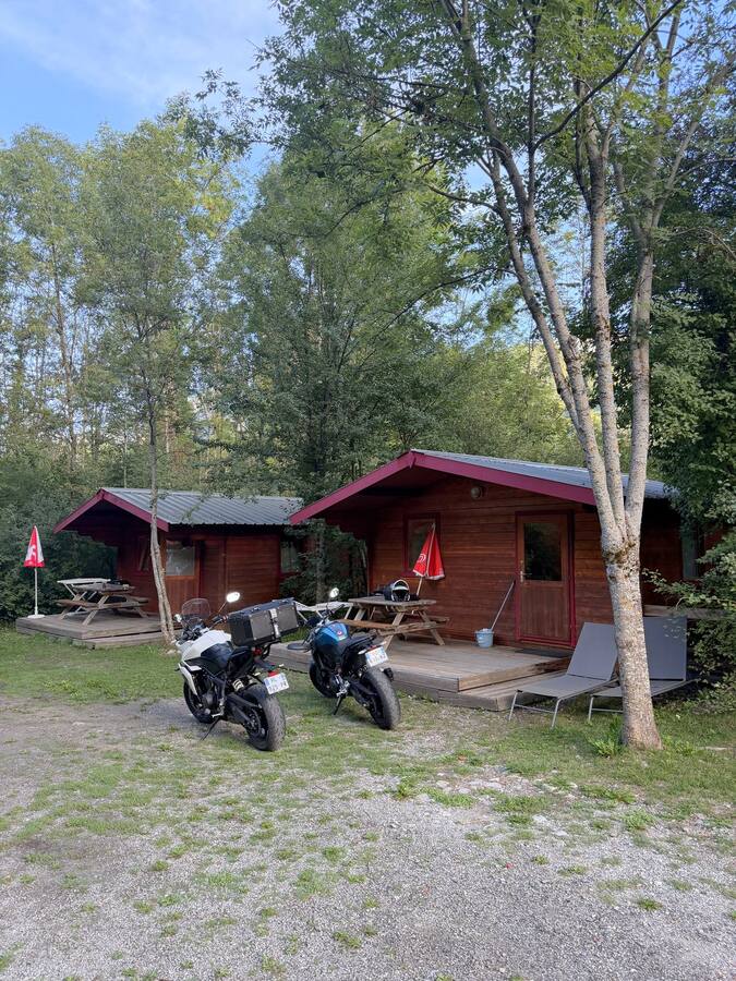 Les deux motos garées devant les chalets du camping des Six Stations au petit matin