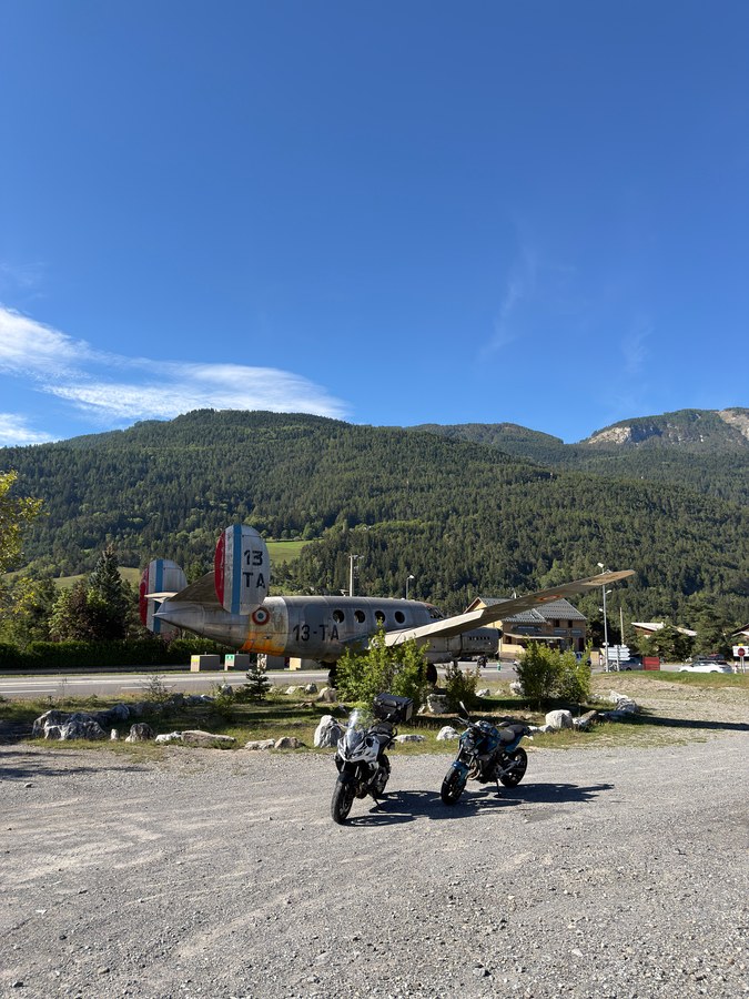 Vieil avion de transport posé en bord de route à Saint-Pons, dans l'Ubaye