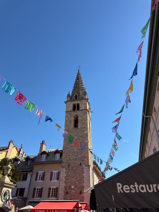 Le clocher de Barcelonnette et les fanions du festival au-dessus des terrasses