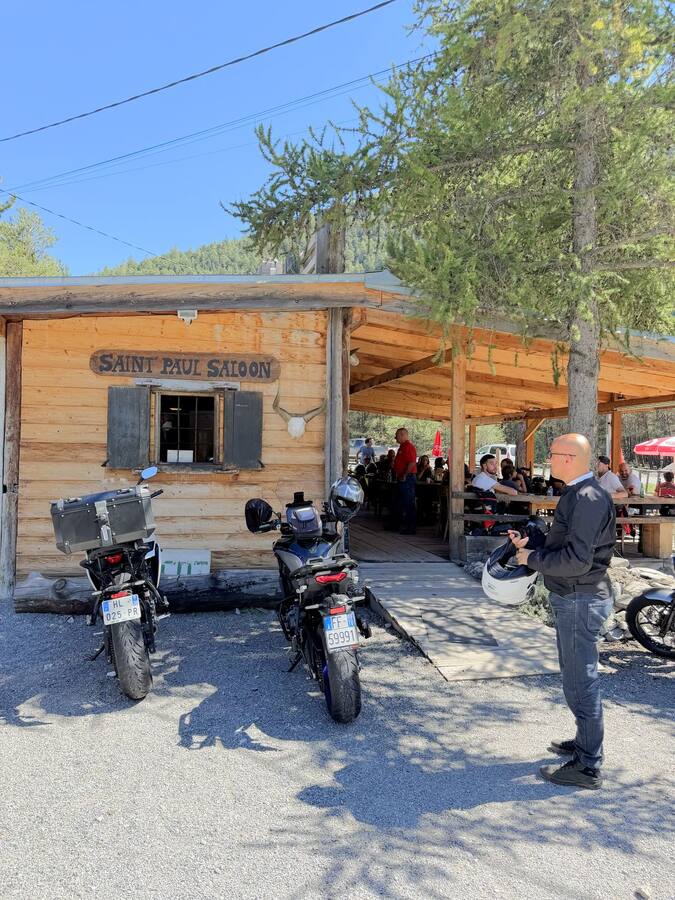 Motos garées devant la terrasse en bois du Saint Paul Saloon, en haute Ubaye